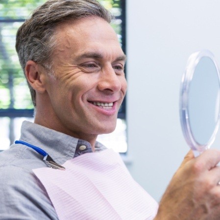 Man looking at smile in the mirror