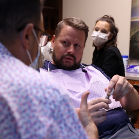 Man discussing dental implants with dentist