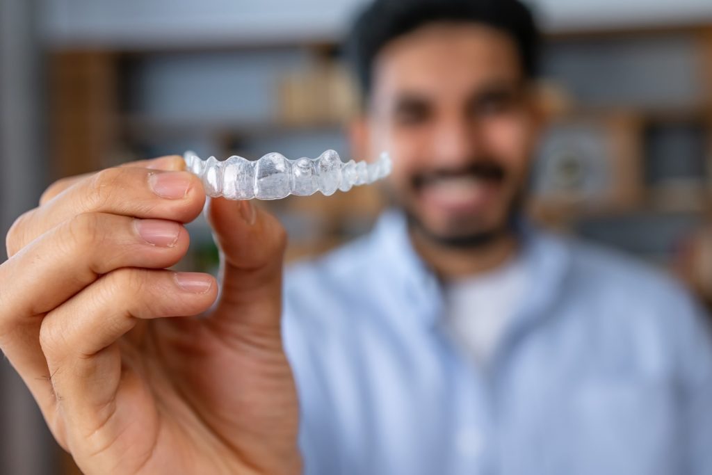 Closeup of patient holding their Invisalign retainer